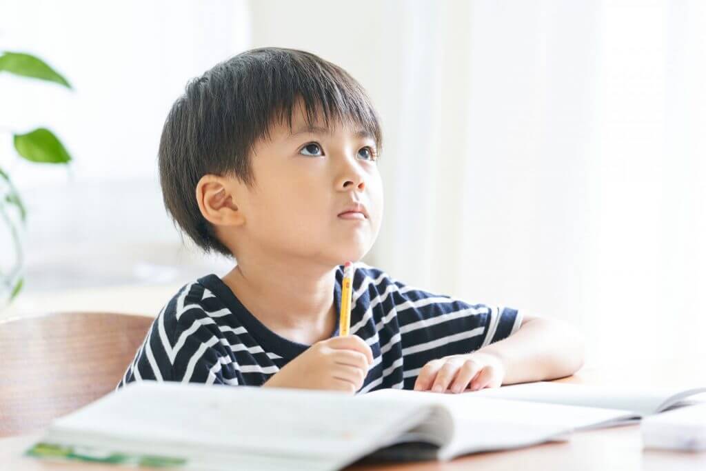 何を書こうか考えている男の子